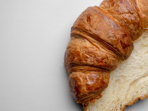 A close-up of a flaky croissant with a golden crust.