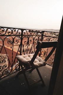 The melara max pillow resting on a balcony chair overlooking a bustling Hong Kong street.