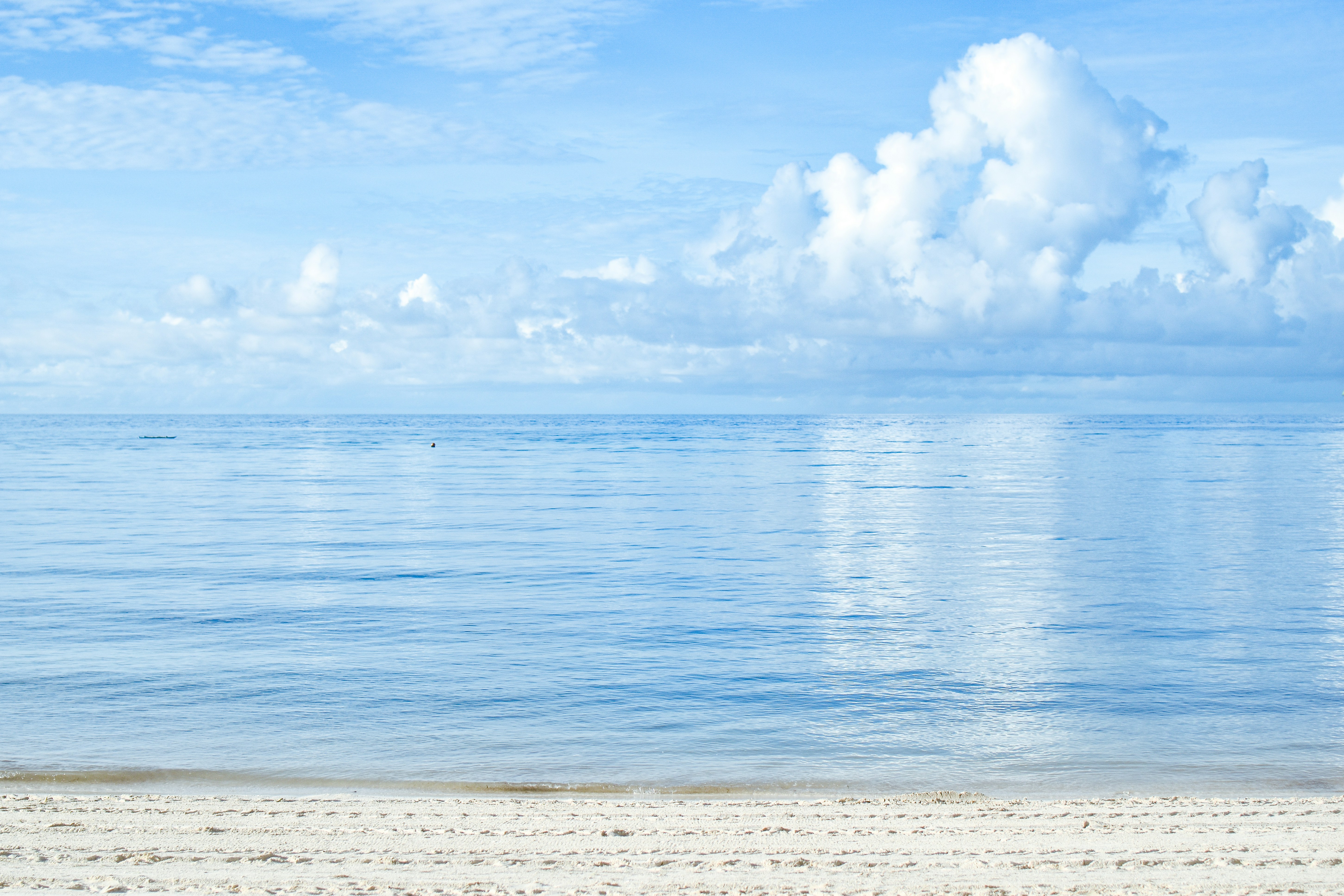 a beach with a body of water and a cloudy sky
