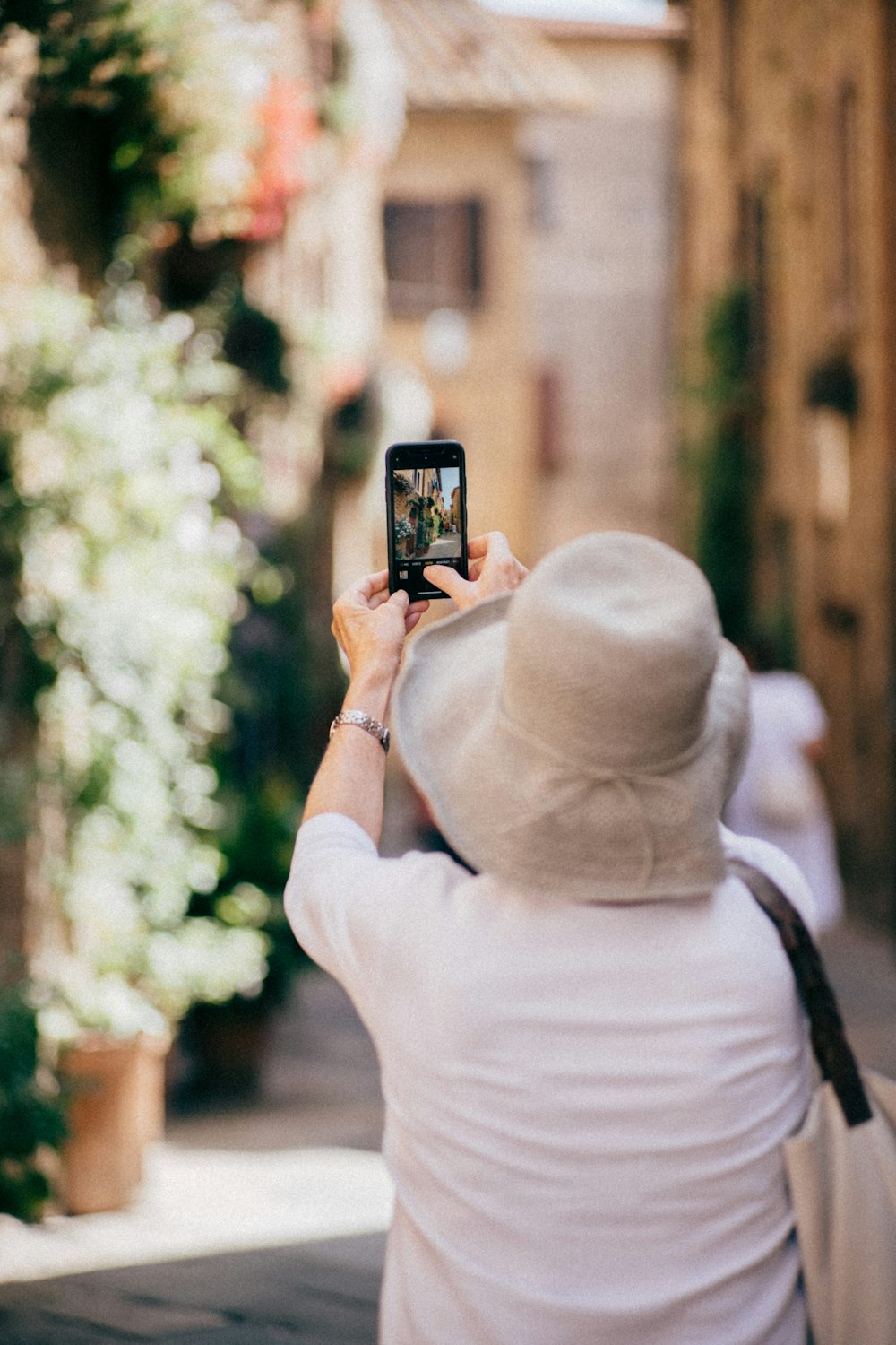 a person taking a picture of a flowered tree