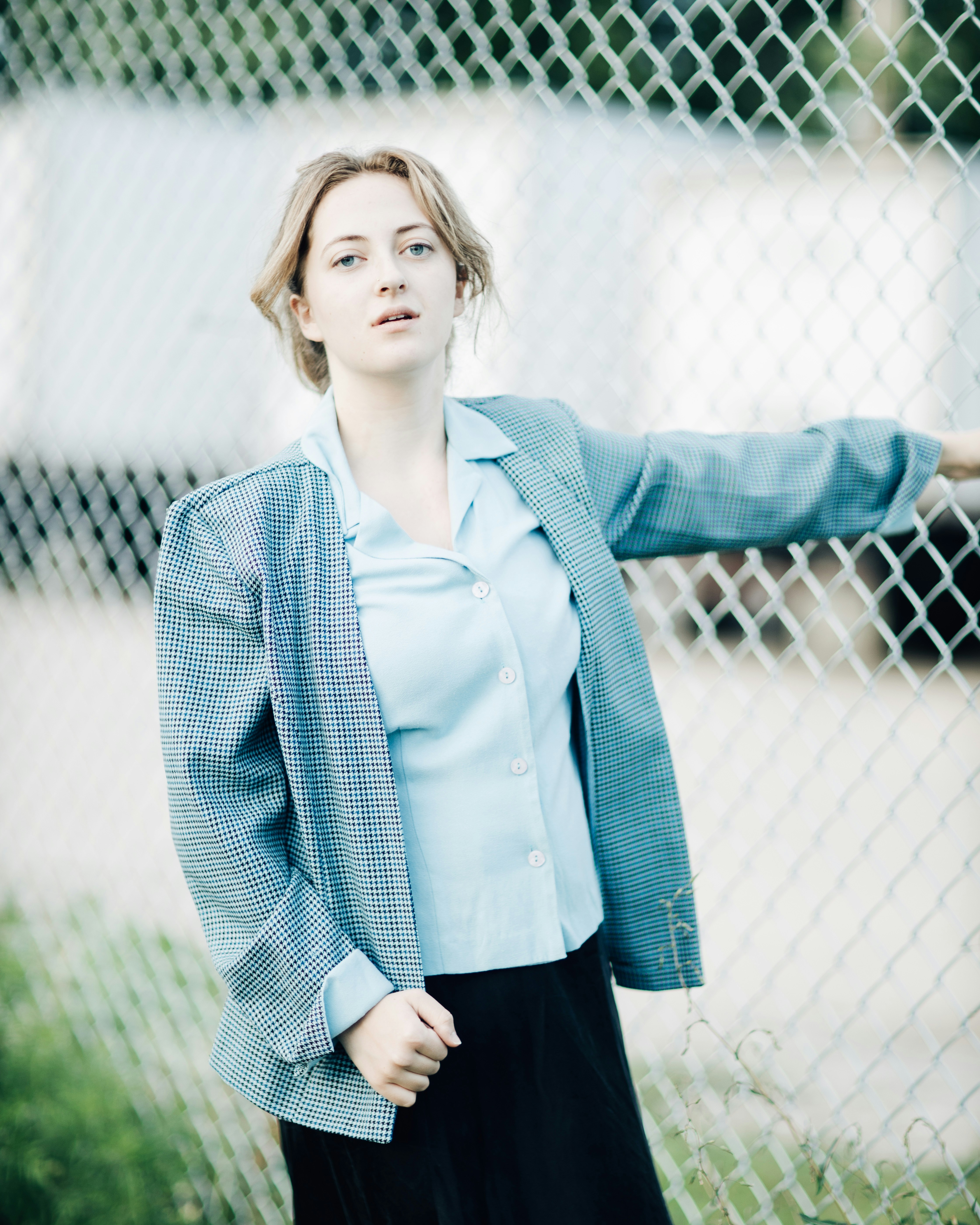 uma mulher em pé na frente de uma cerca