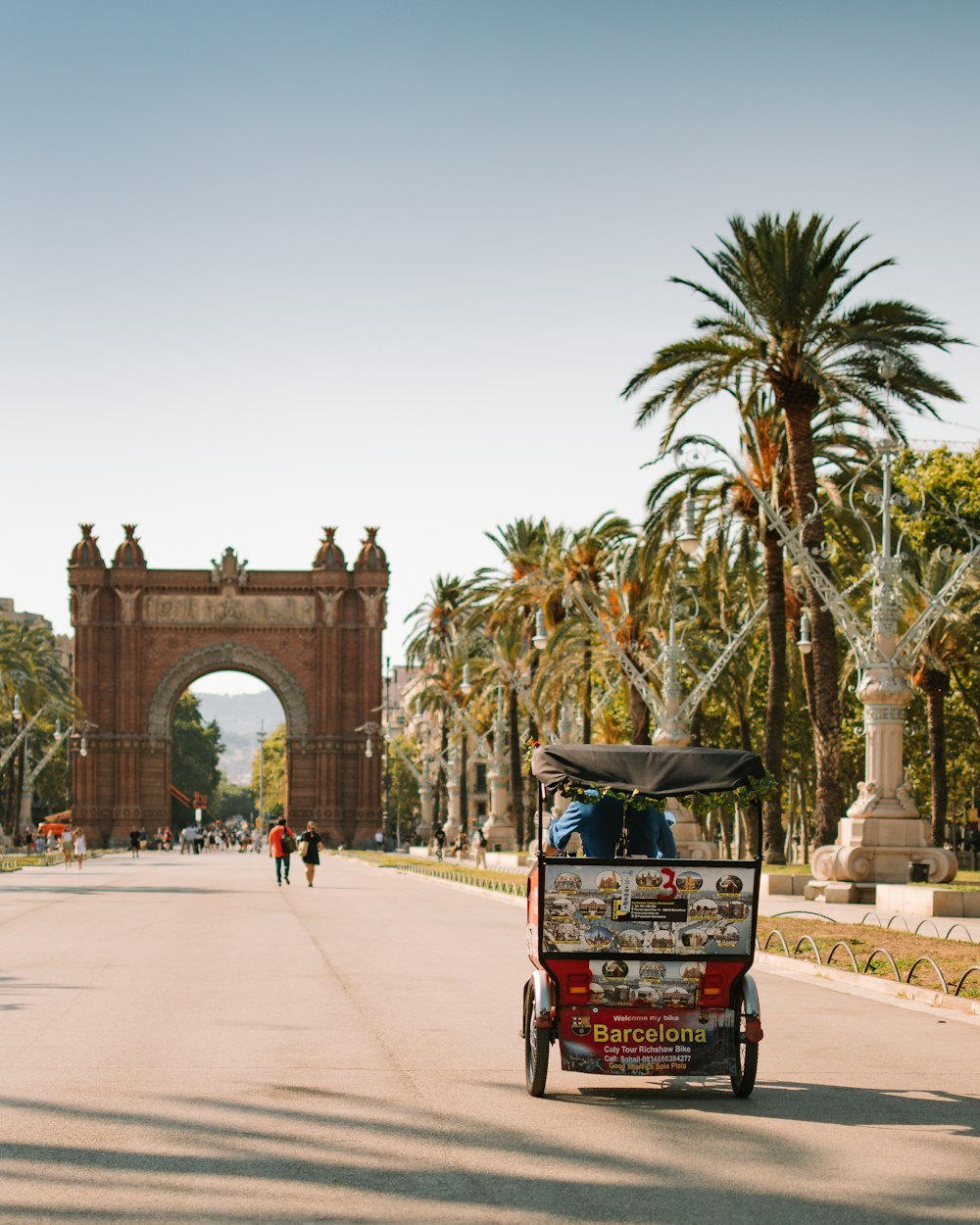 a cart with a person in it on a road with a large archway