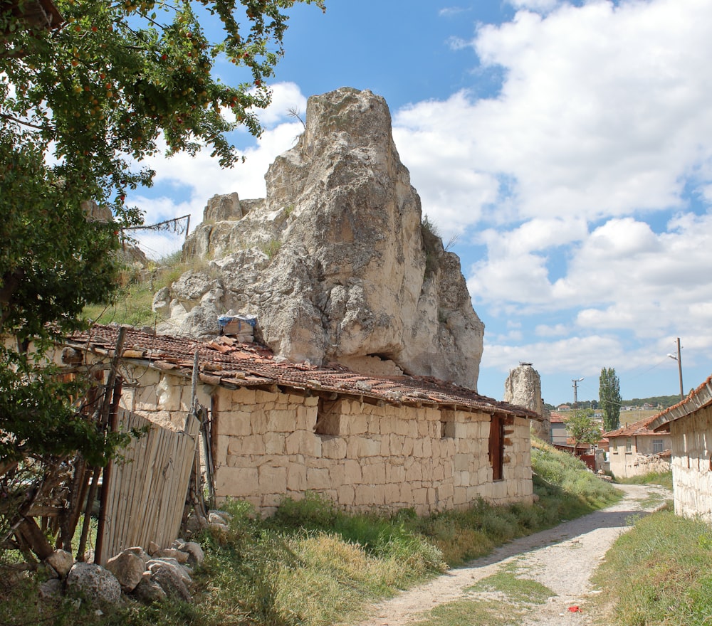 un bâtiment en pierre surmonté d’un gros rocher