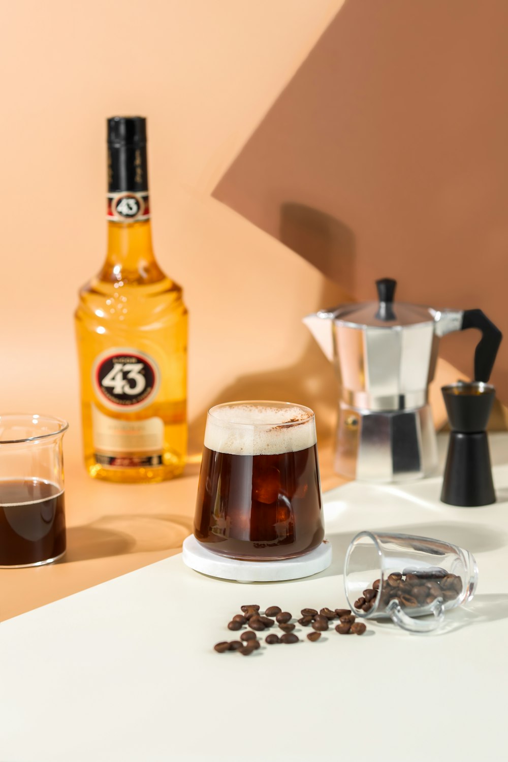 a glass of liquid and a bottle of alcohol on a table