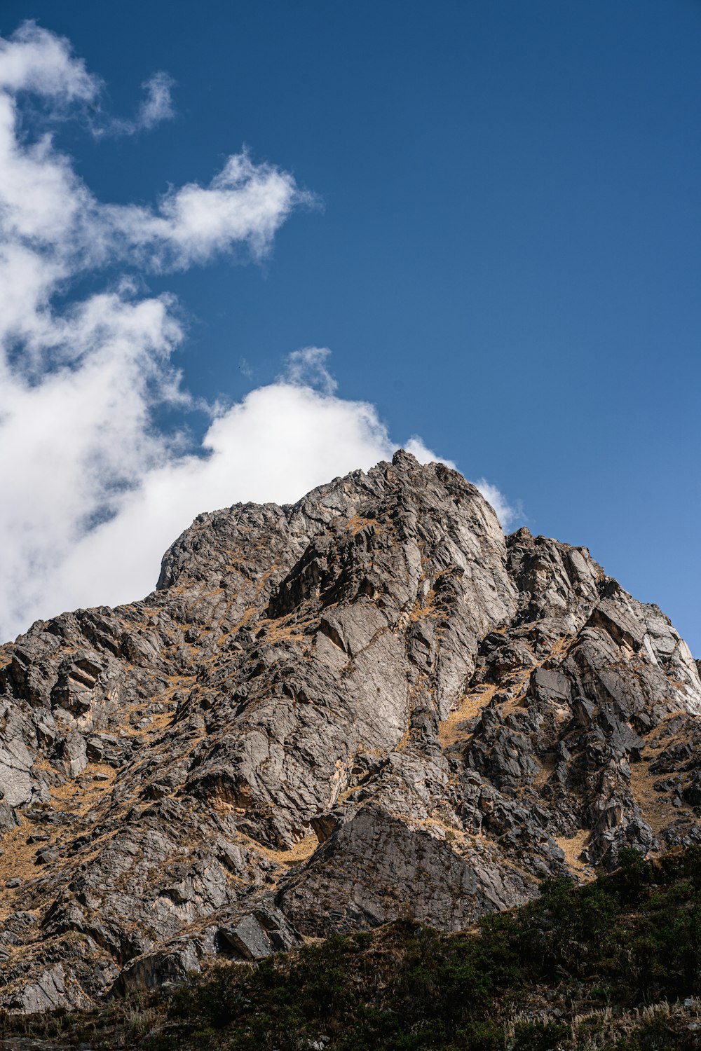 a rocky mountain with a blue sky