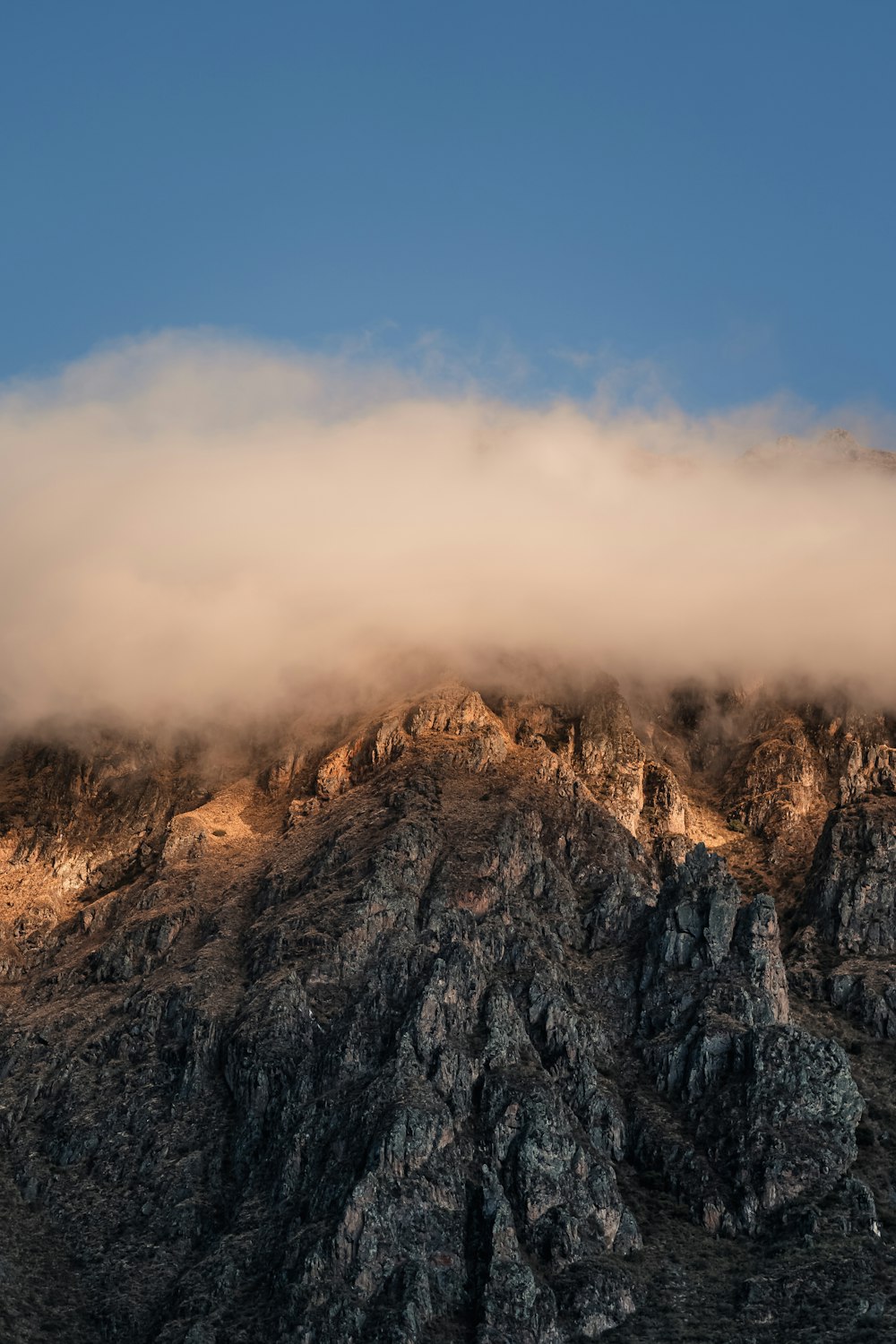 a rocky mountain with a blue sky