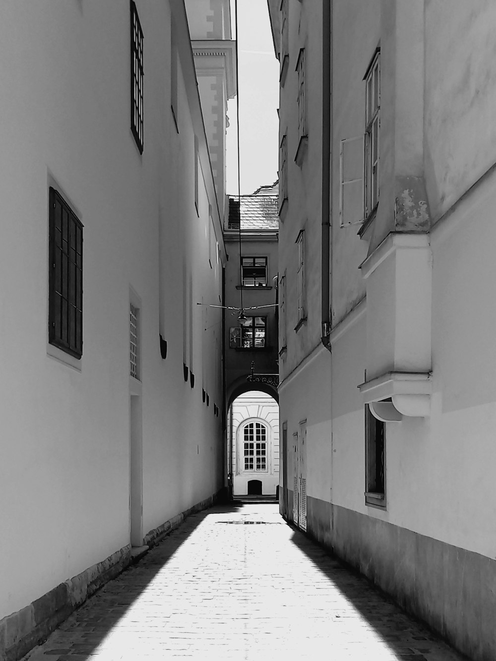 a narrow alley way with white buildings