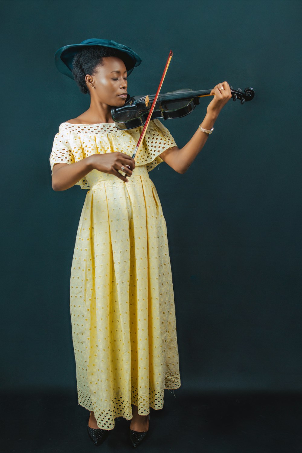 a person in a yellow dress playing a violin