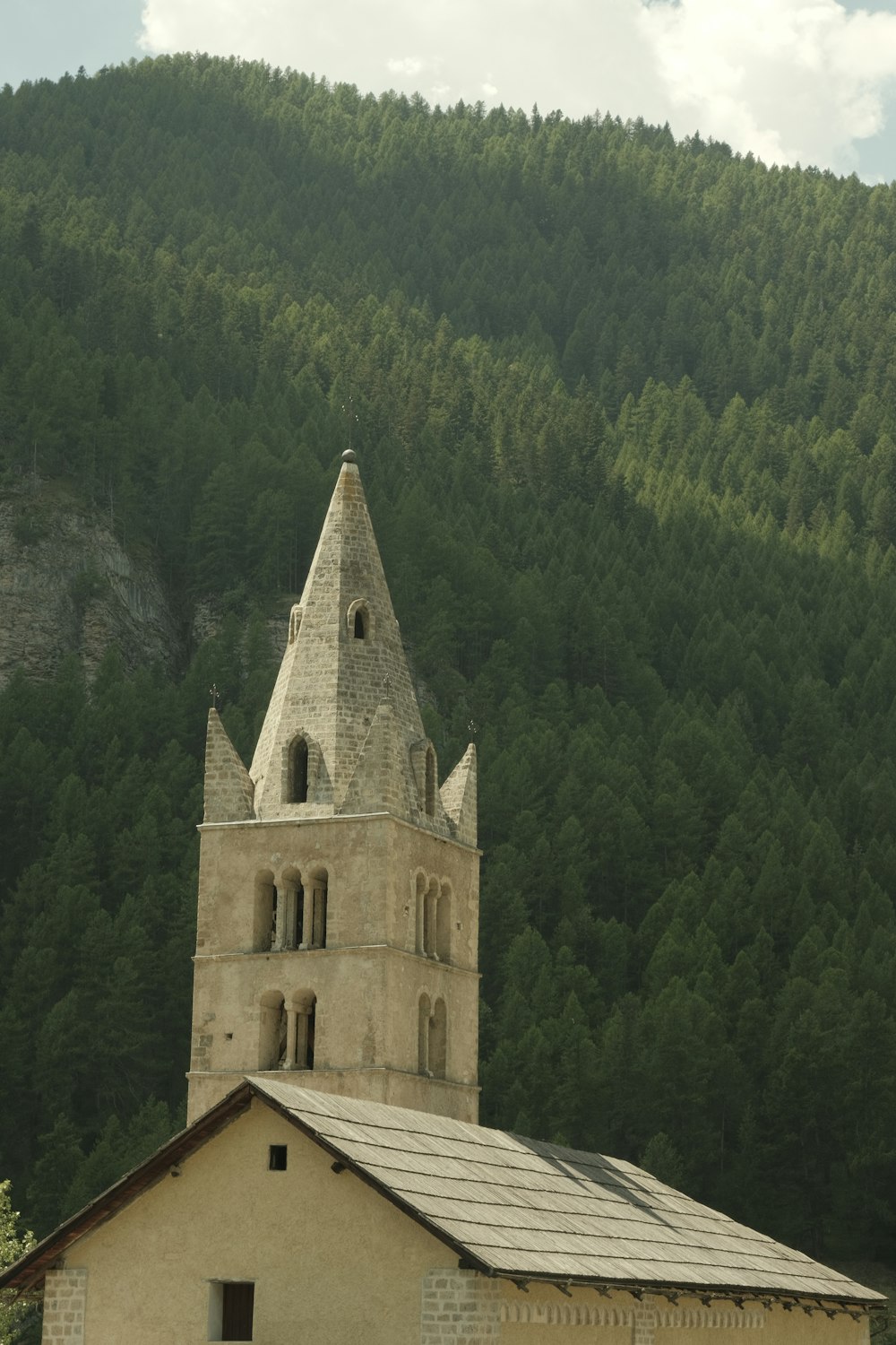 a building with a steeple and trees in the background