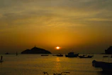 Sunset over the calm waters of Saona Island with colorful boats anchored nearby.