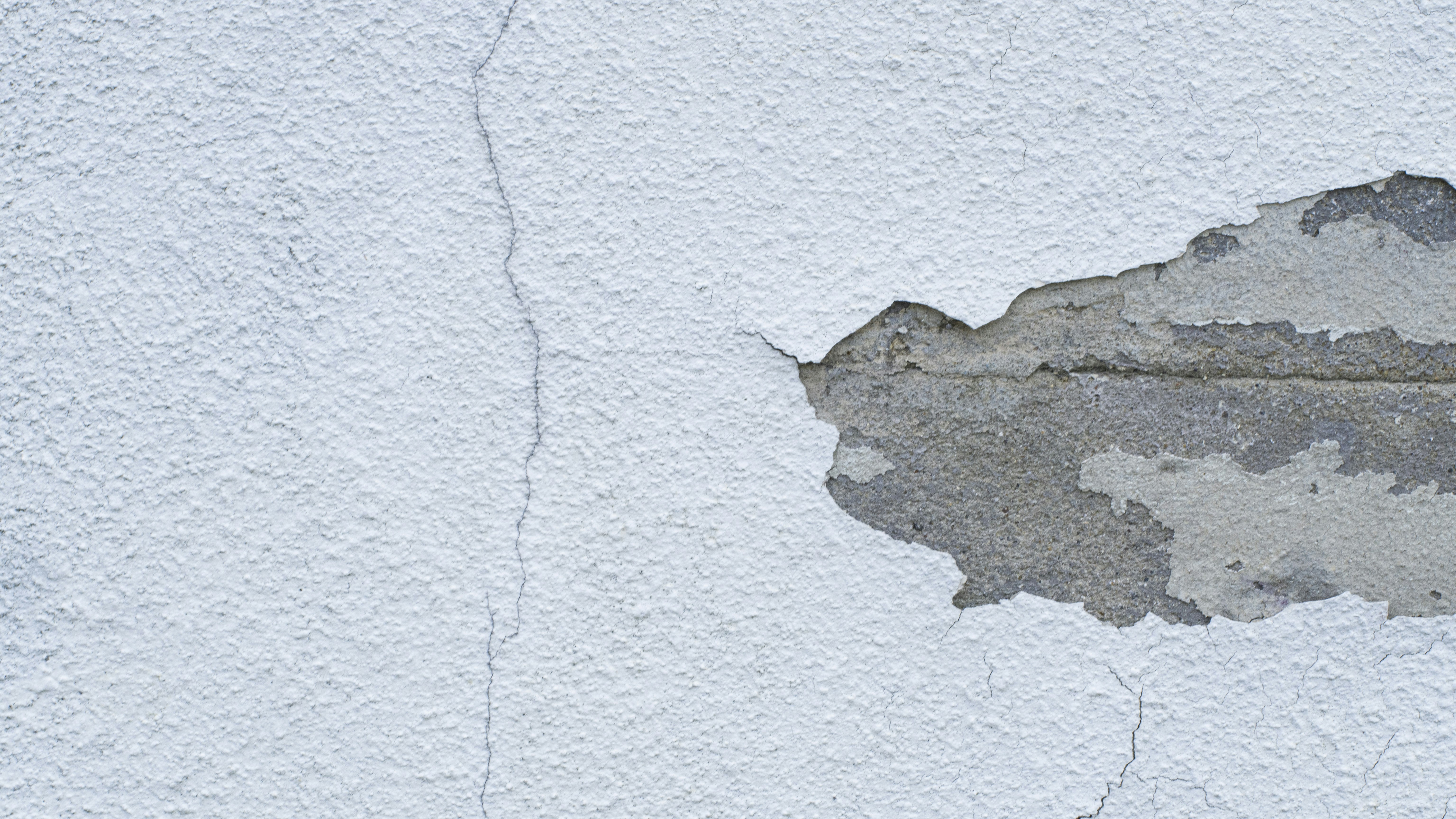 Foundation settlement causing visible cracks along building base.