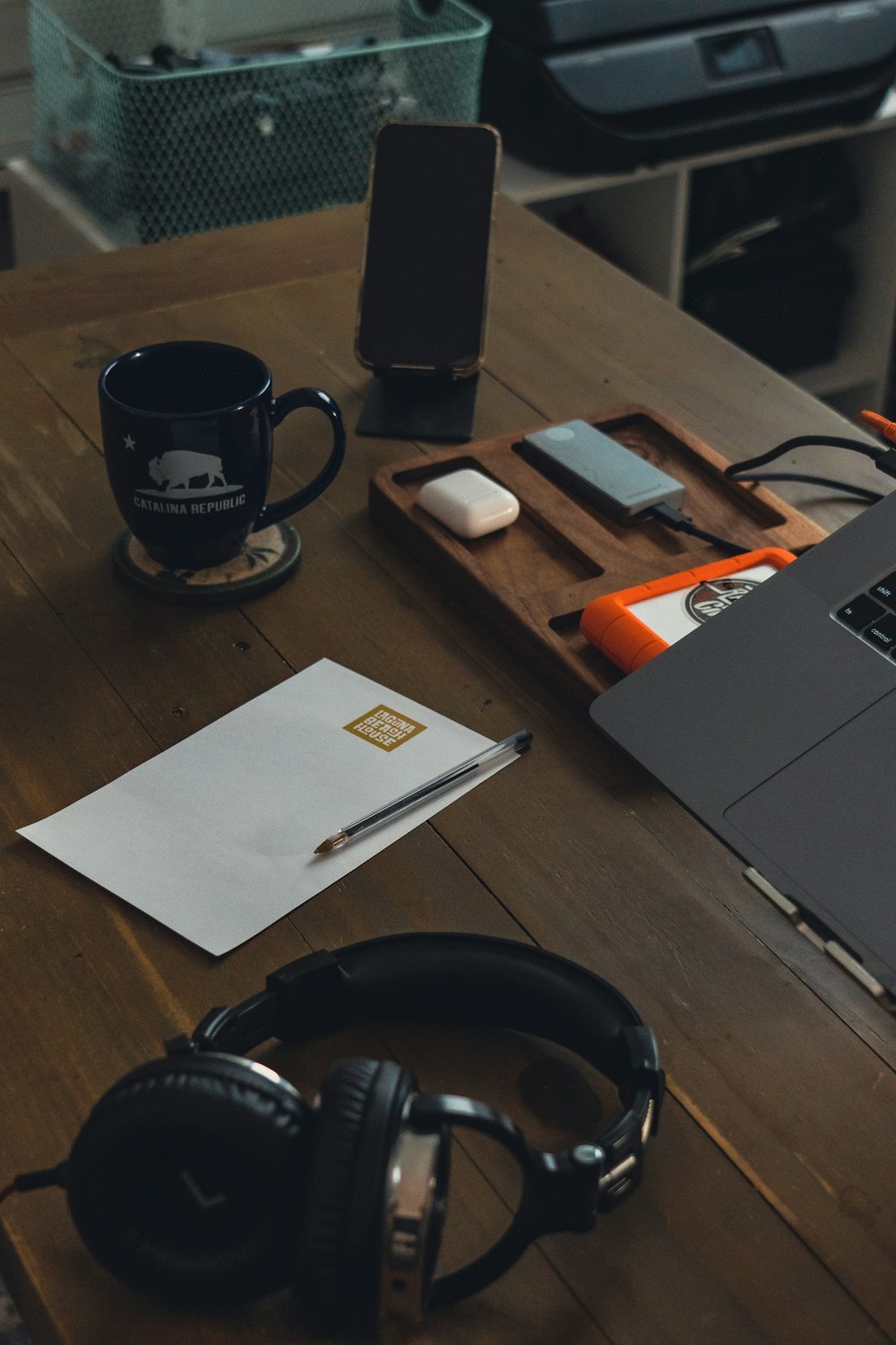 a desk with a mug and headphones on it