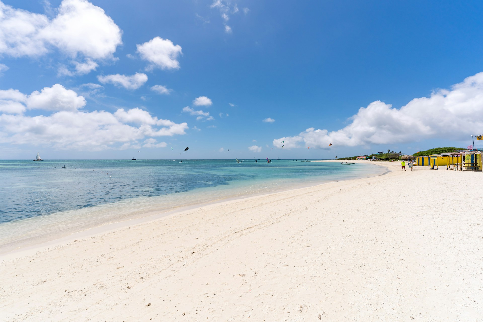 a beach with blue water and clouds