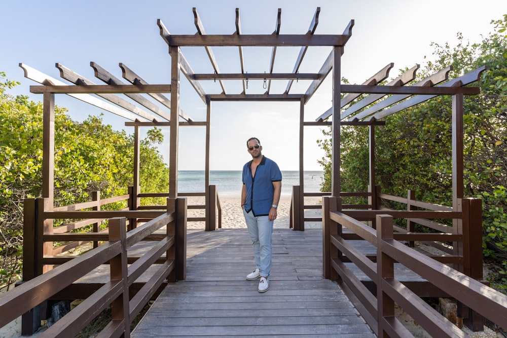 a man standing on a wooden bridge