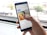 A hand is holding a smartphone in front of a window. On the screen, a Google search for 'Selden Standard' is displayed, showing images and details of the restaurant including ratings and directions.