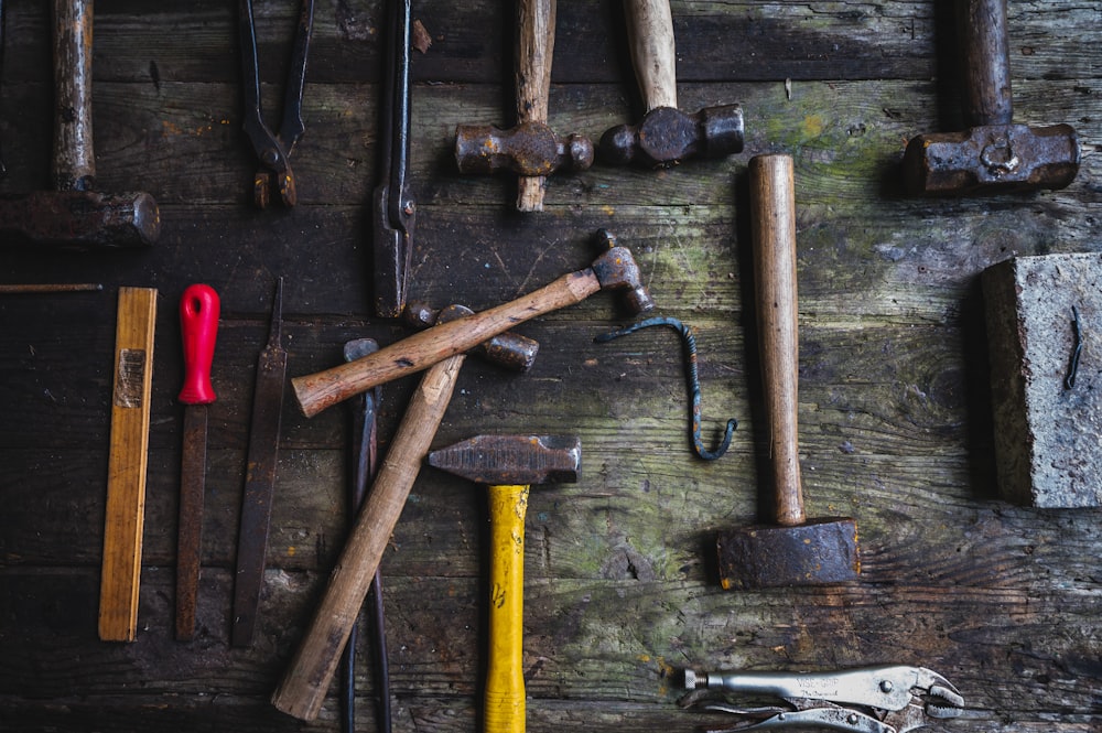 a group of hammers and a hammer on a wooden surface