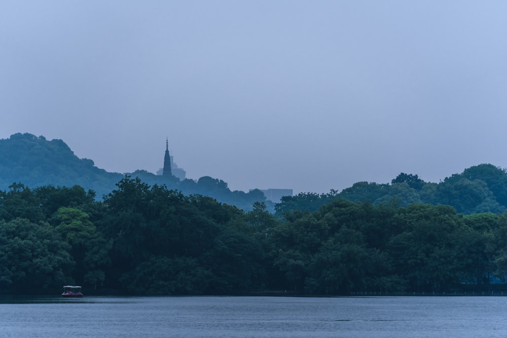 a body of water with trees and a building in the distance