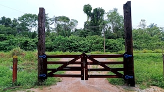 a wooden gate in a field