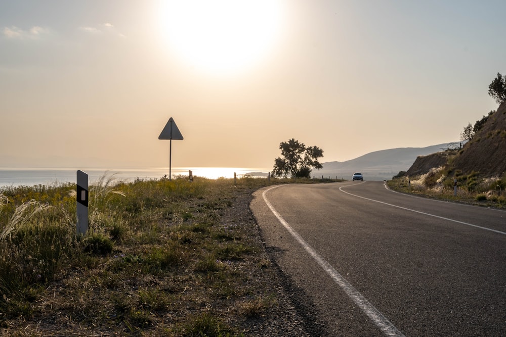 a road with a car on it by a body of water