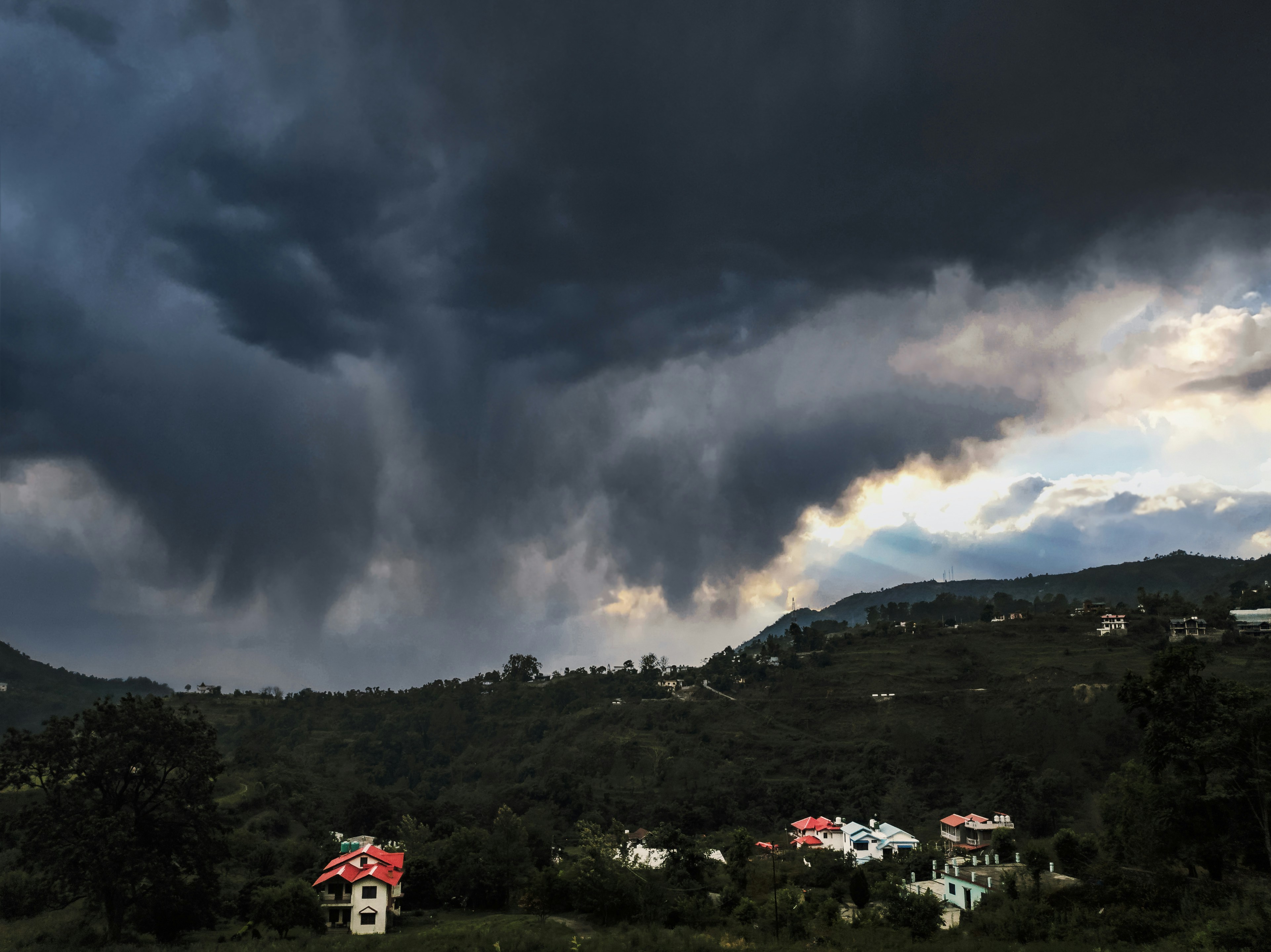 Dark storm cloud forming over a residential neighborhood - Expert roof repair