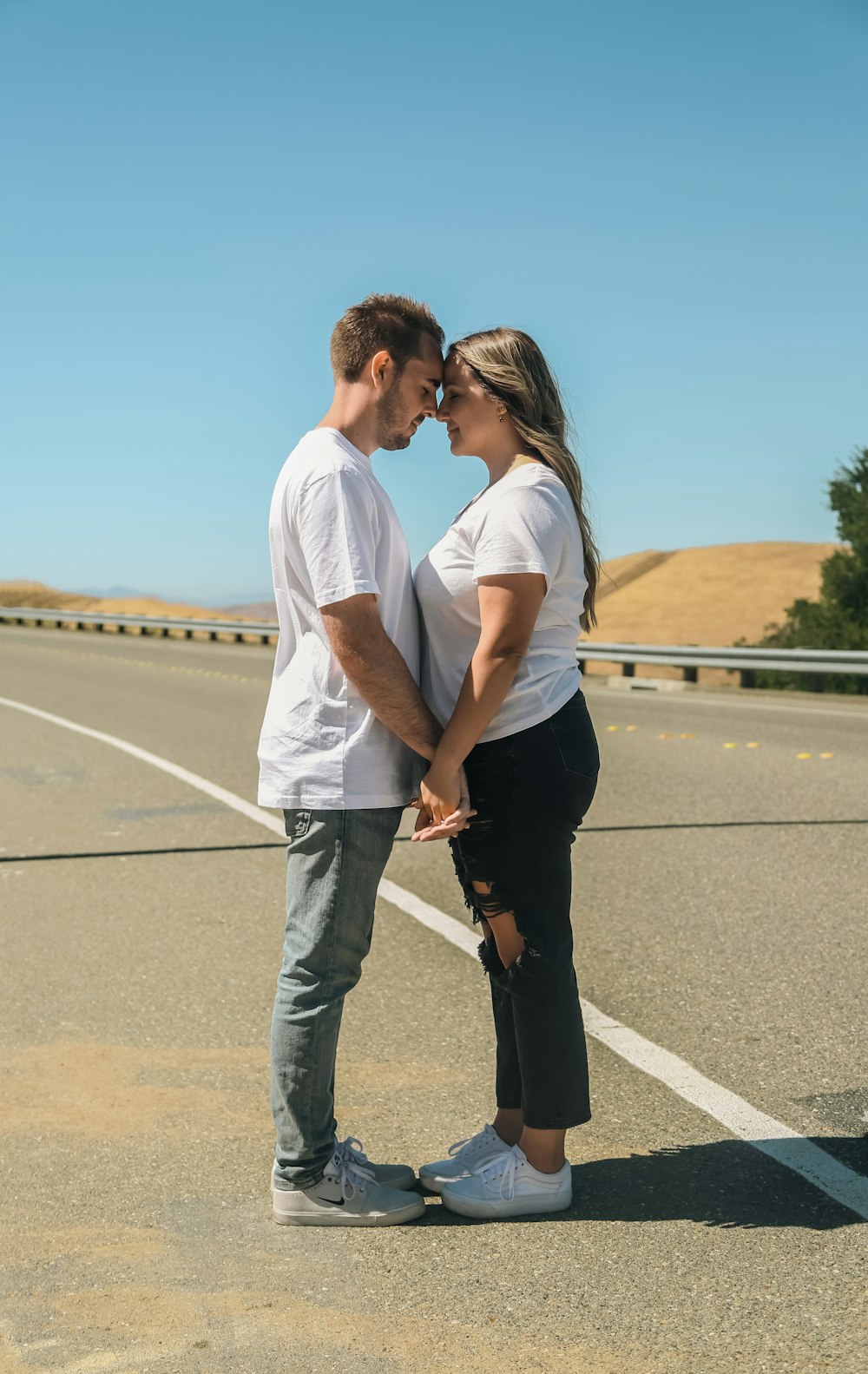 Un homme et une femme s’embrassent sur une route