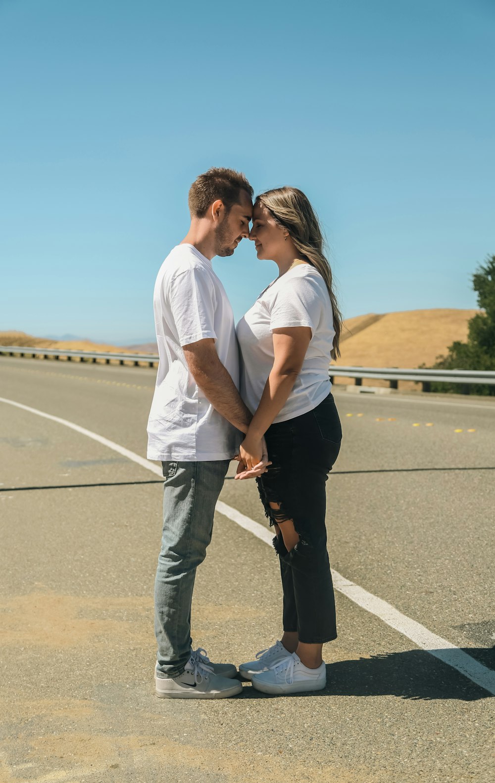 a man and woman kissing on a road