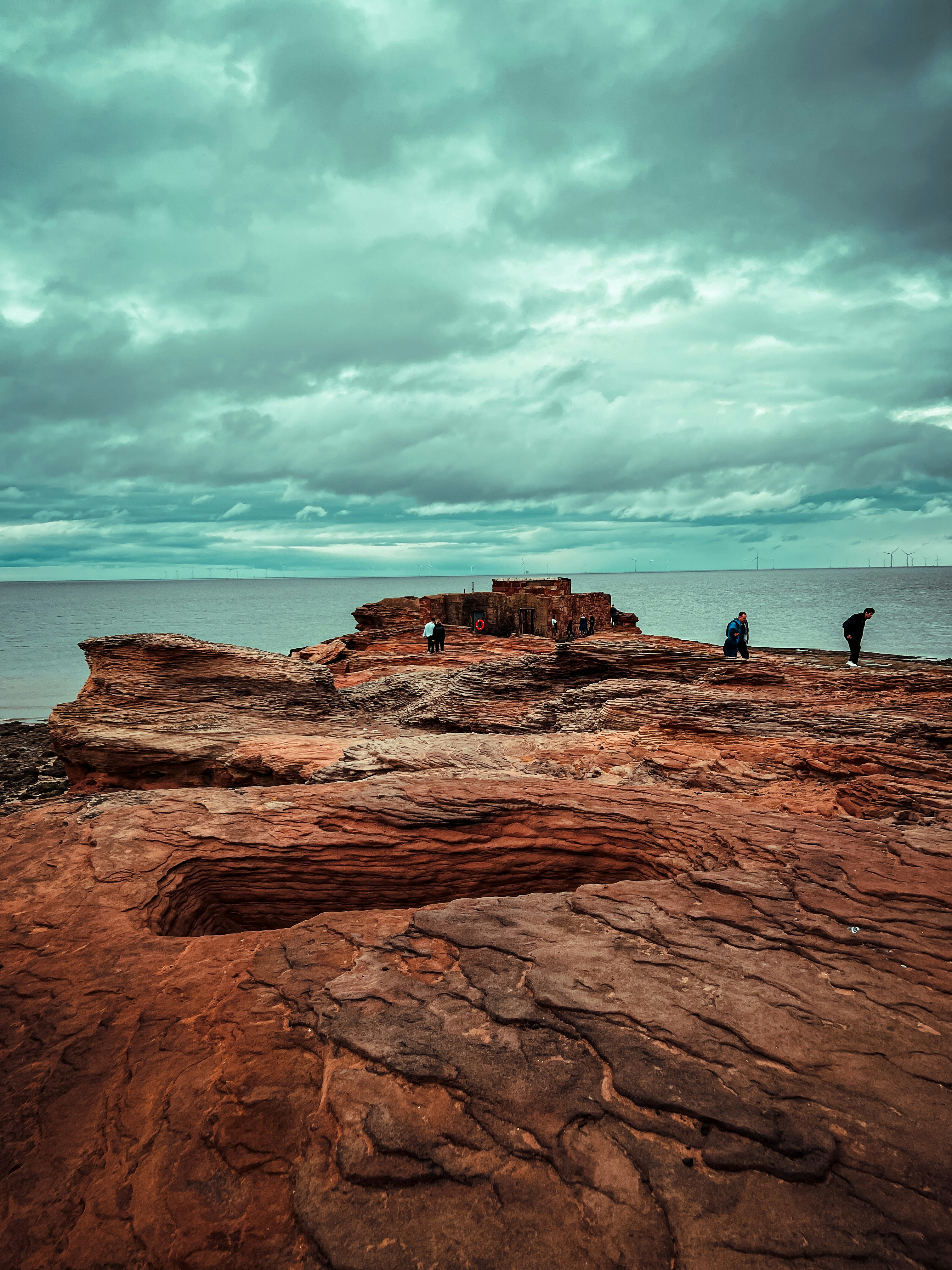 a group of people standing on a rocky beach