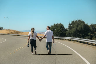 a man and a woman walking on a road