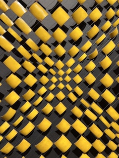 An abstract geometric pattern in dark tones with yellow accents.