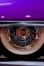 Close-up of a wheelchair wheel with a vibrant, custom-designed hub cap featuring bold colors and patterns.
