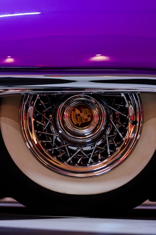 Close-up of a wheelchair wheel with a vibrant, custom-designed hub cap featuring bold colors and patterns.