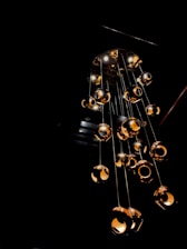 A friendly technician installing a modern chandelier in a cozy living room with warm lighting.