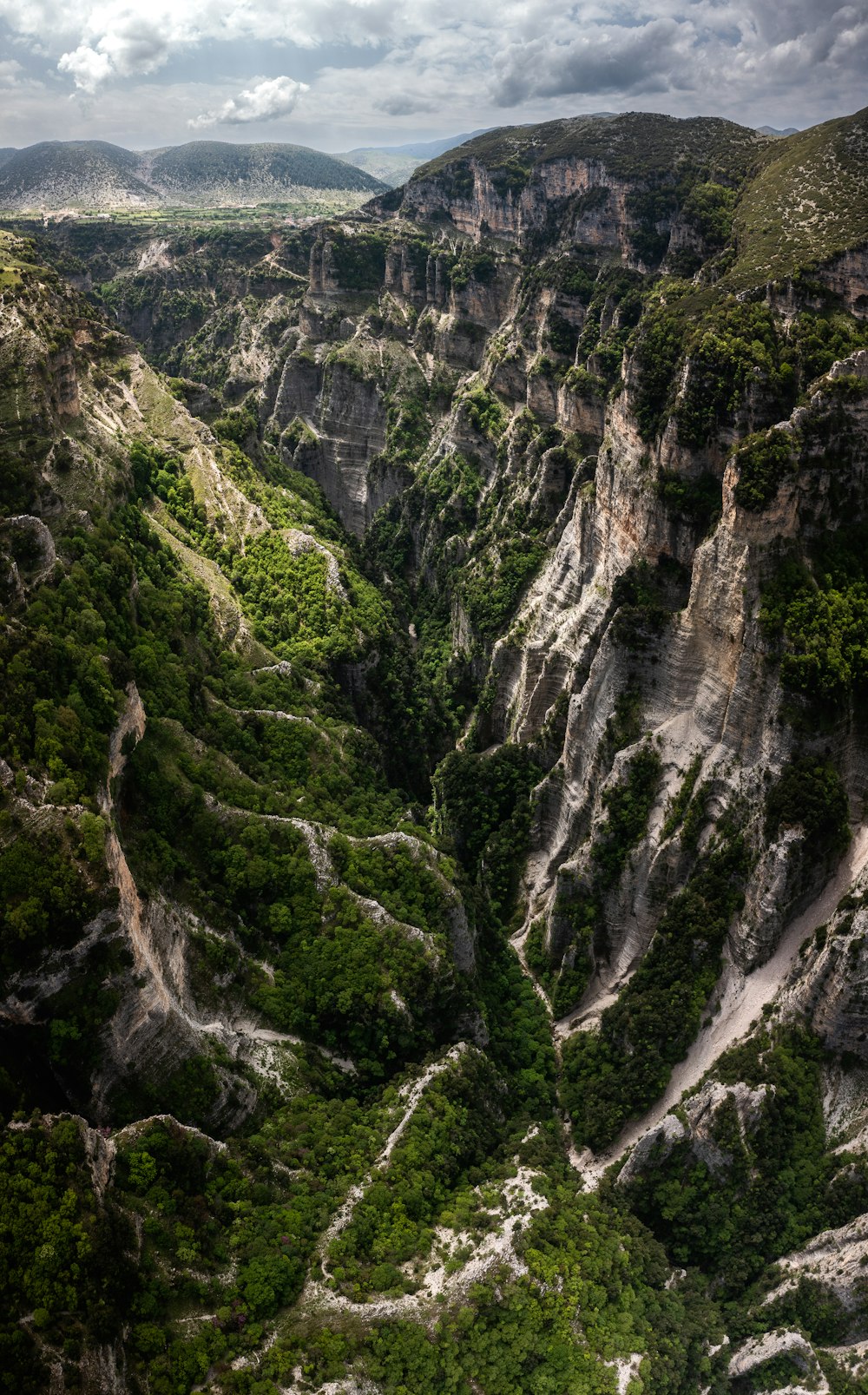 a rocky cliff with a river running through it