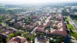 An aerial view of a sprawling university campus with green lawns and contemporary buildings.