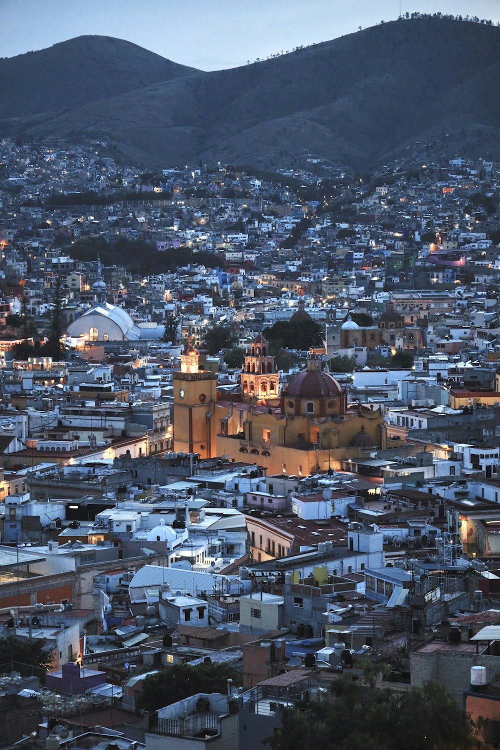 a city with many buildings and mountains in the background