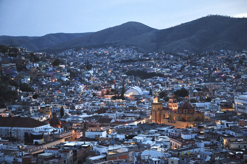 a city with many buildings and mountains in the background