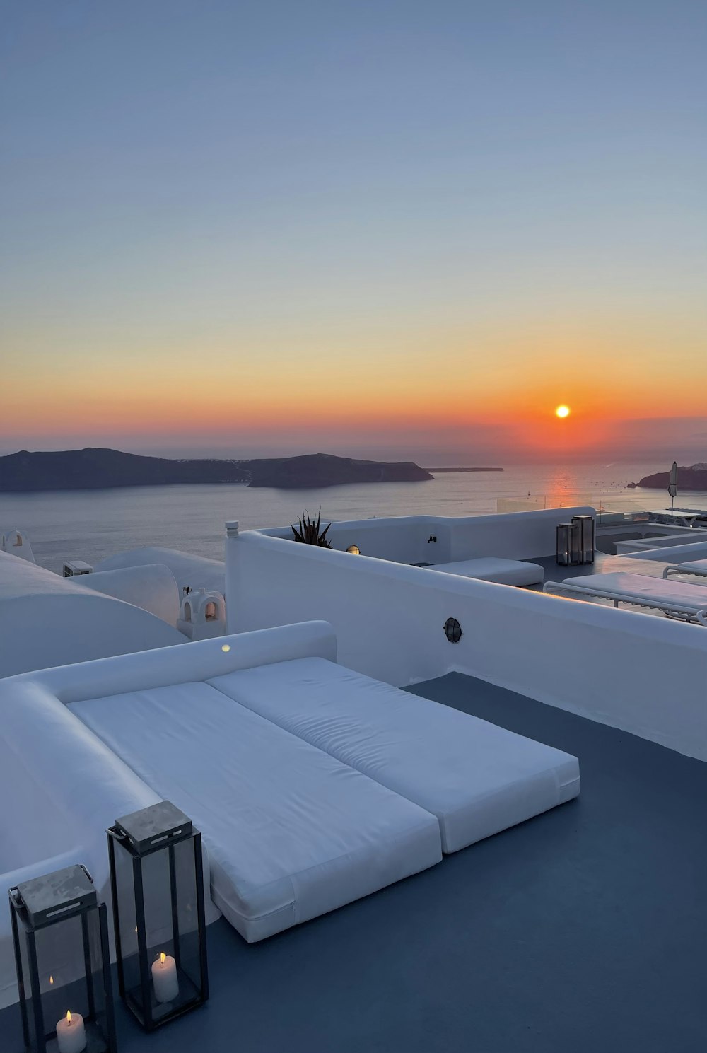 a group of white rooftops with a sunset in the background