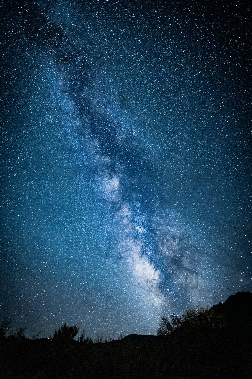 a starry night sky over a mountain range