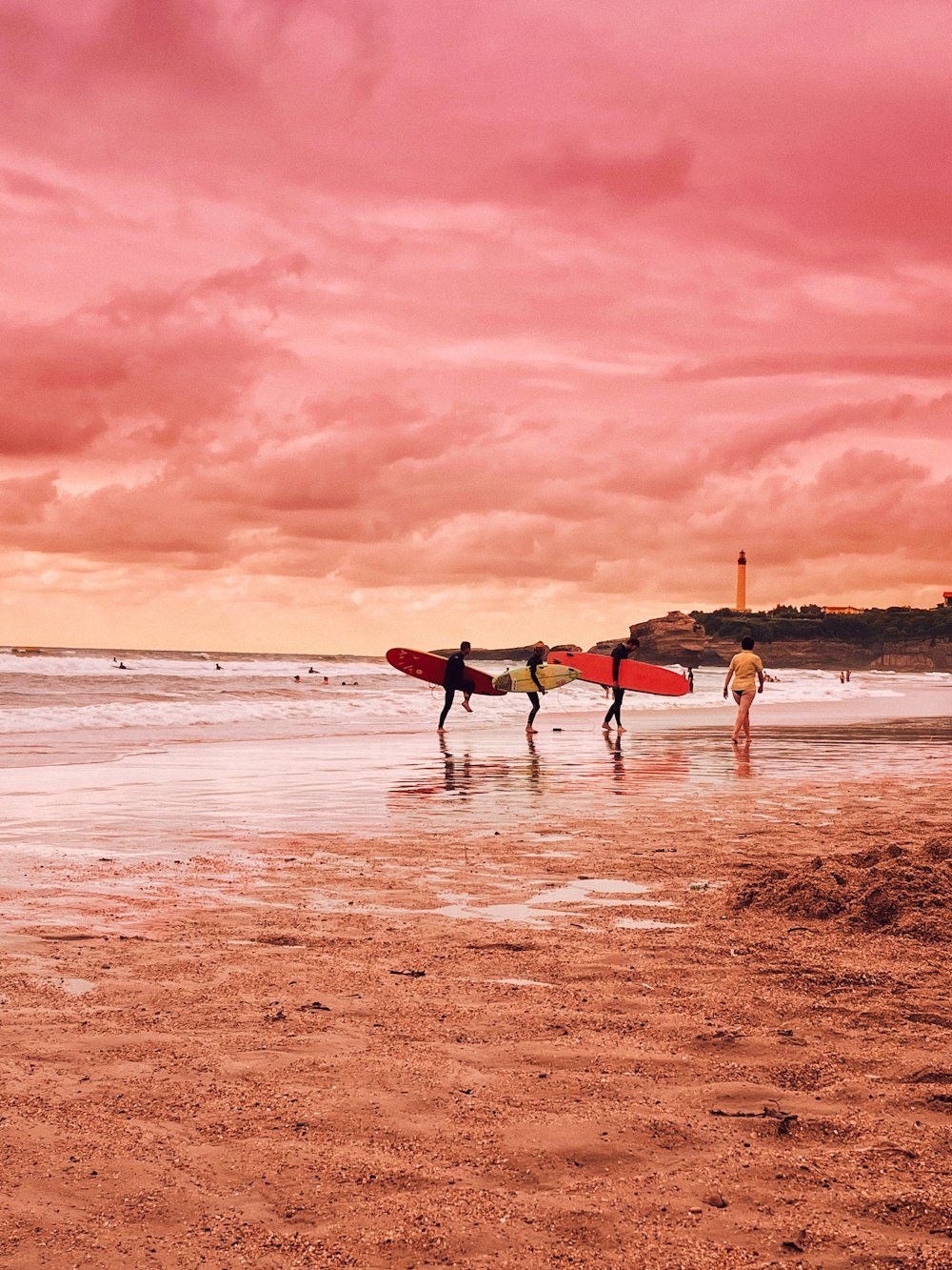 um casal de pessoas carregando pranchas de surf em uma praia