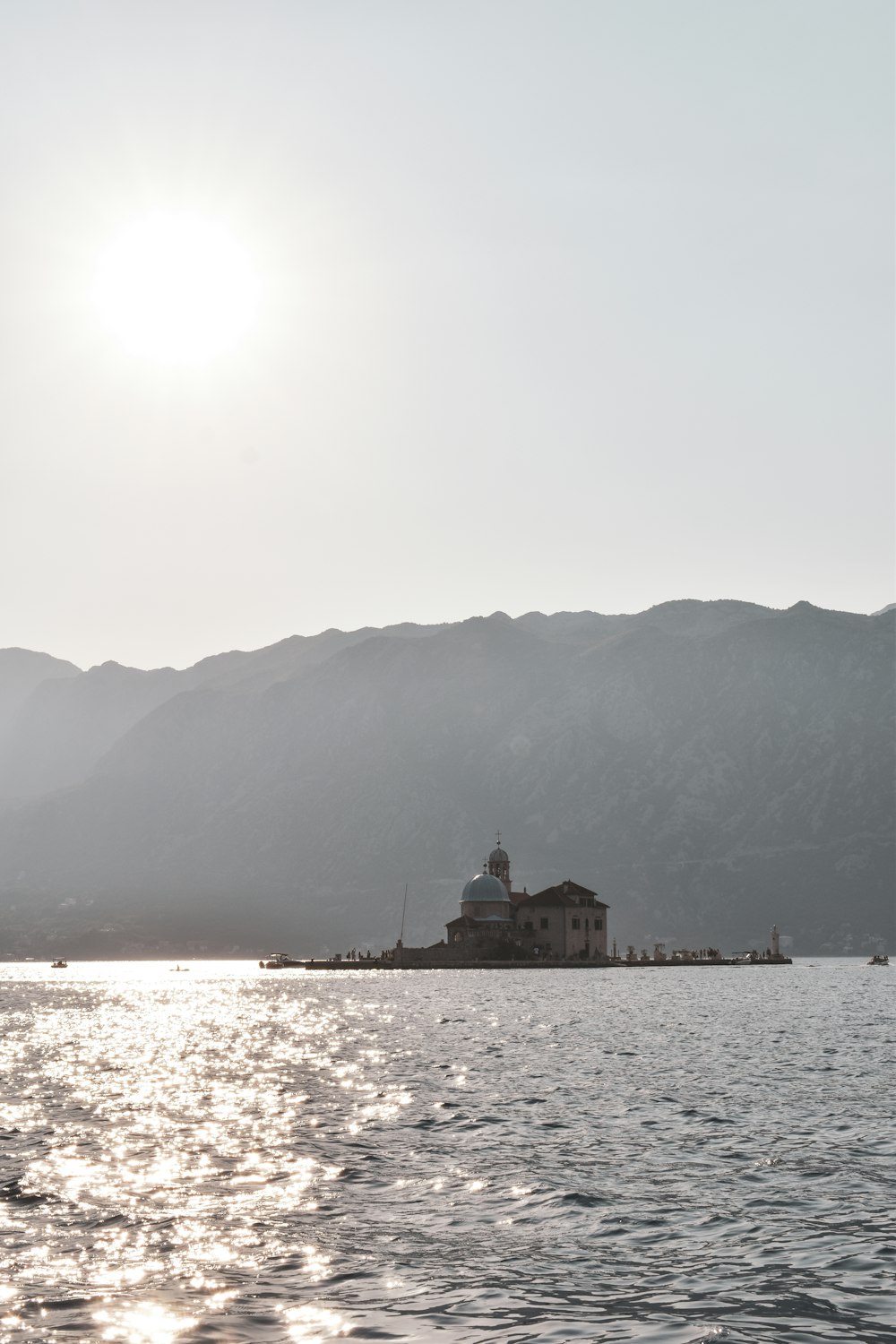 a building on a dock by the water with mountains in the background