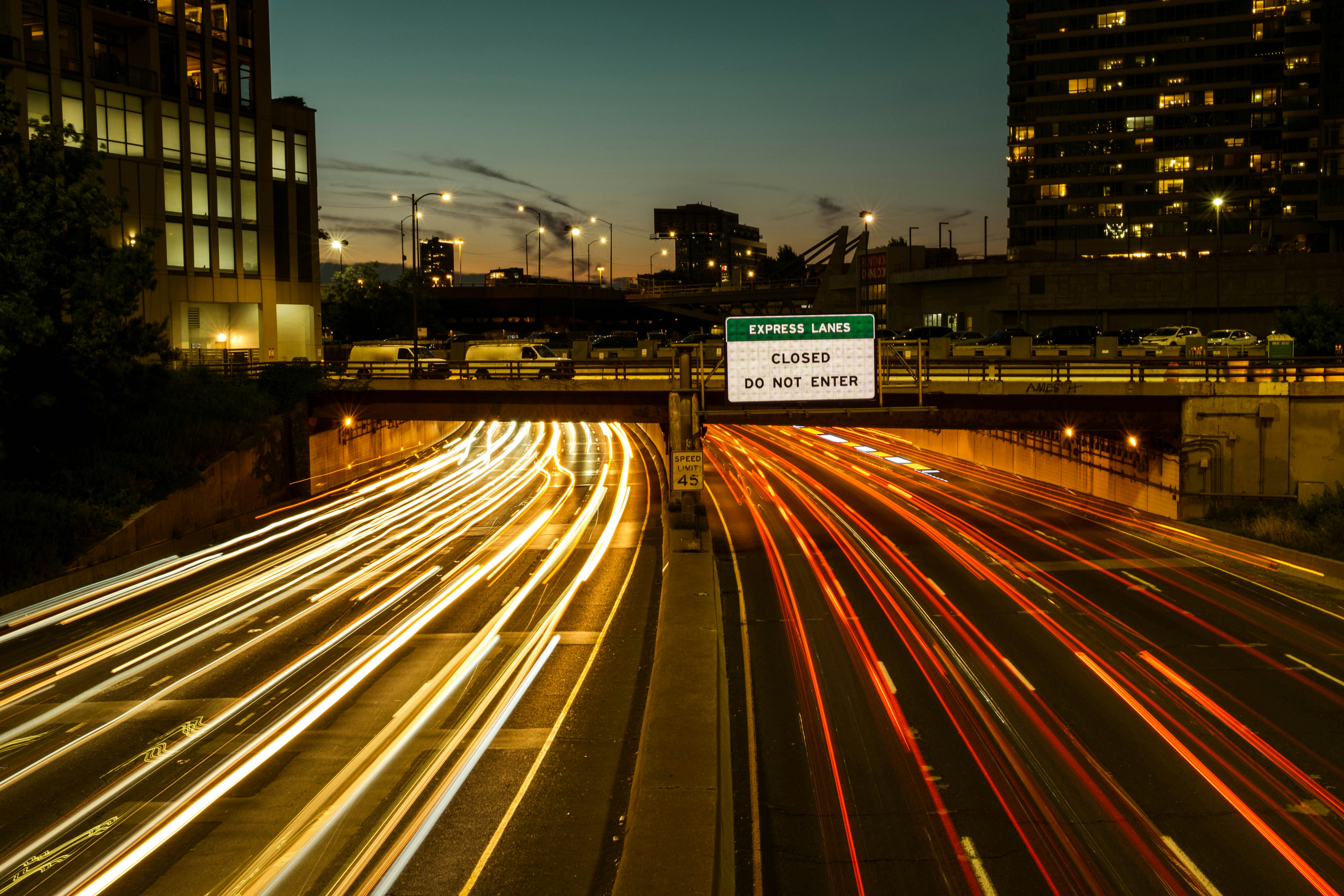 cars drive under a bridge on a highway one summer evening in chicago