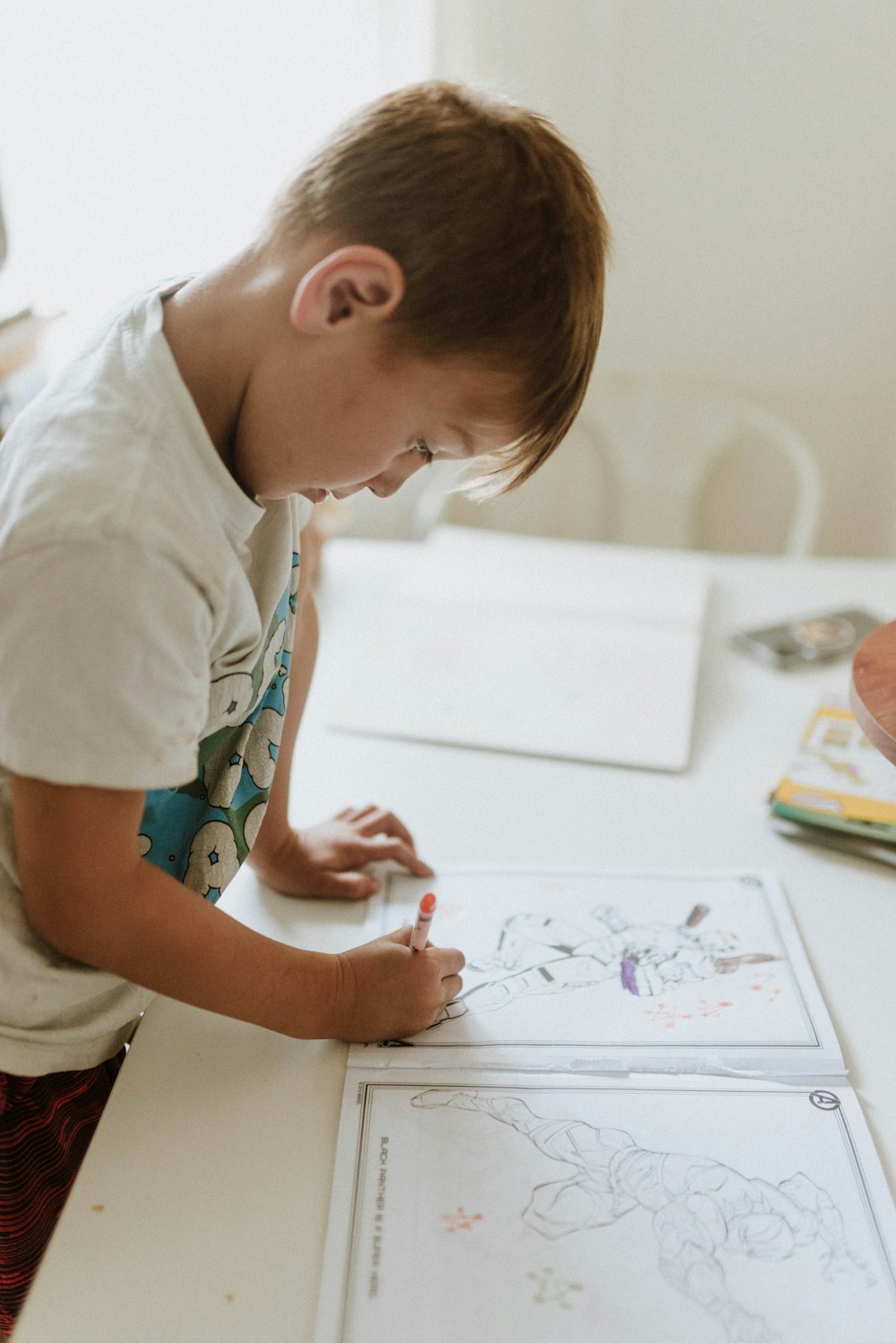 a young boy drawing on a white board
