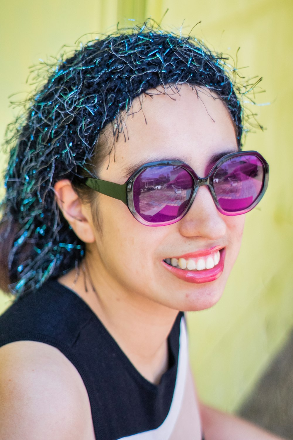 a woman with curly hair wearing sunglasses