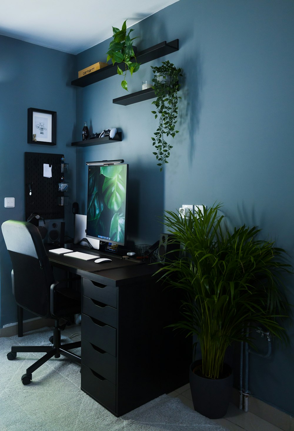 a desk with a computer and plants