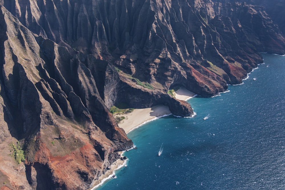 a rocky cliff next to a body of water