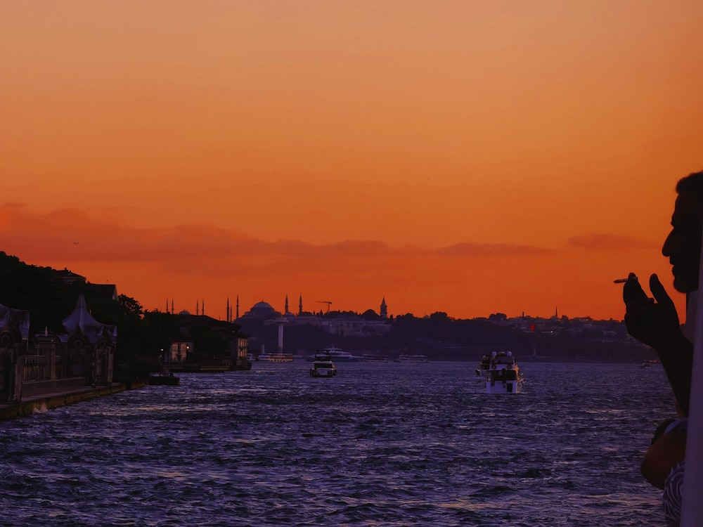 a person taking a picture of a sunset