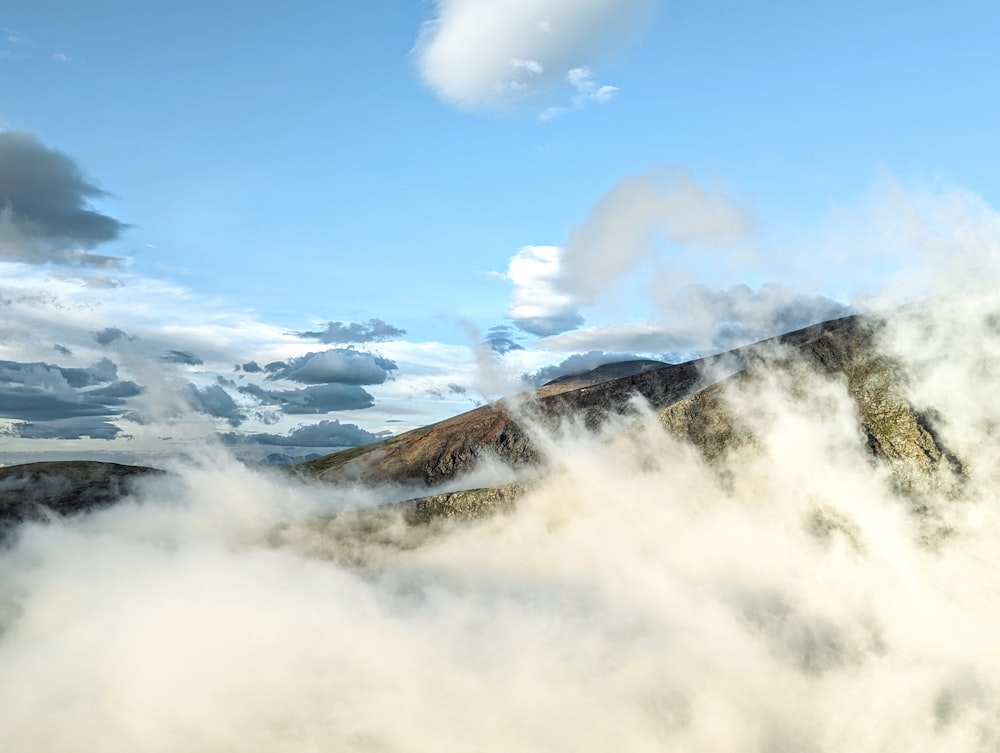 a mountain with clouds below