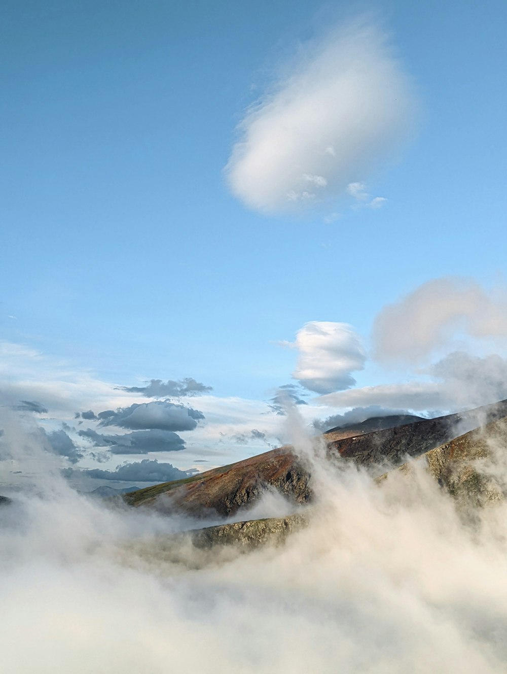 a mountain with clouds below