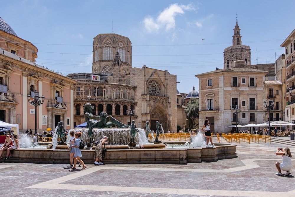 a fountain in a courtyard with buildings in the background