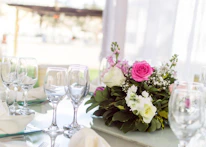 Close-up of pink and gold themed table setting with delicate floral arrangements.